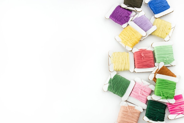 kolorowe nici i igły na lnianym tle